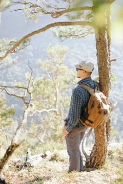 Backpacker man standing near the tree. Stock Photos