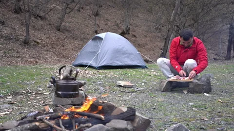 Backpacker Preparing Meat by Campsite 動画素材 303664686