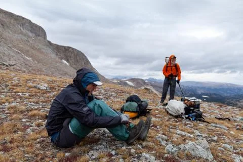Backpacker puts on rain gear -  Wind River Range, Wyoming Stock Photos