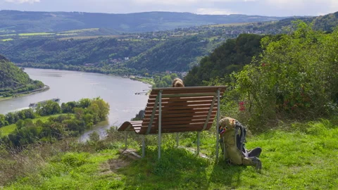 Backpacker relaxing on bench at a viewpoint overlooking the Rhine River Valley Stock-Footage 303670180