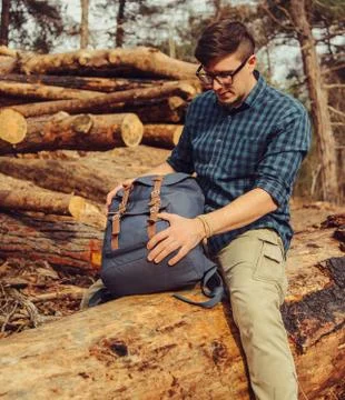 Backpacker sitting on wood trunk Stock Photos