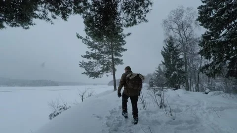 Backpacker on a snowy lake, stopping for a quick photo of this amazing view Stock Footage 146729428