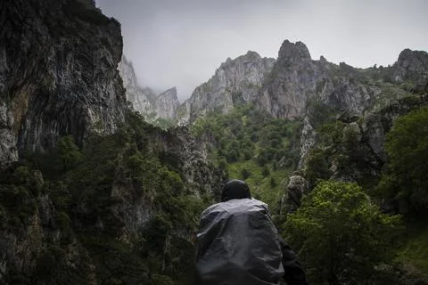 A backpacker stands looking at the sharp cliff edges Stock-Fotos