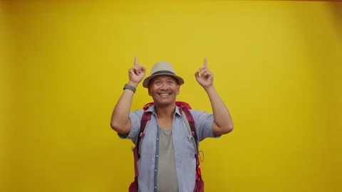 Backpacker in a Straw Hat and Red Backpack Gesturing Toward Blank Copy Space Stock Footage 336994981