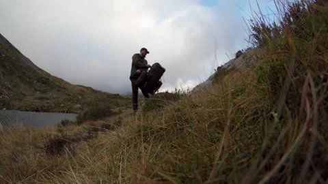 A backpacker taking off his large bag in then countryside 스톡 동영상 168742082