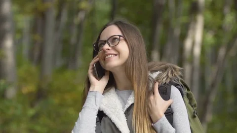 Backpacker Talks on Phone in Forest Stock Footage 81132690