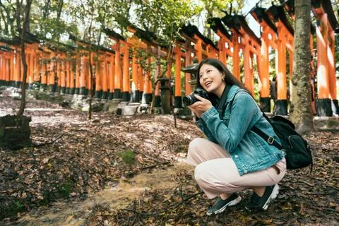 Backpacker in temple holding professional camera Stockfoto's