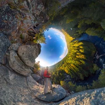 Backpacker on top of a rock fall at dawn. spherical degree panorama 360 180 l Stock Photos