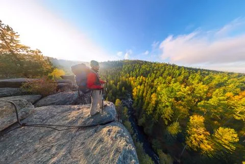 Backpacker on top of a rock fall at dawn. Wide angle aerial panorama Stock Photos