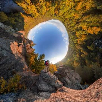 Backpacker on top of a rock fall at dawn. spherical degree panorama 360 180 l Stock Photos