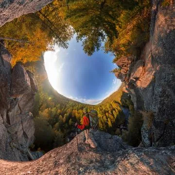 Backpacker on top of a rock fall at dawn. spherical degree panorama 360 180 l Stock Photos