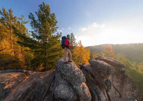 Backpacker on top of a rock fall at dawn. Wide angle aerial panorama Stock Photos