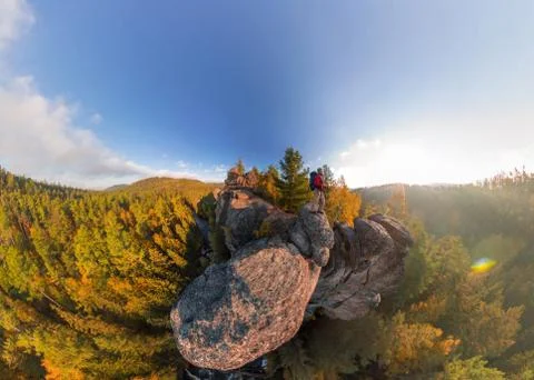 Backpacker on top of a rock fall at dawn. Wide angle aerial panorama Stock Photos