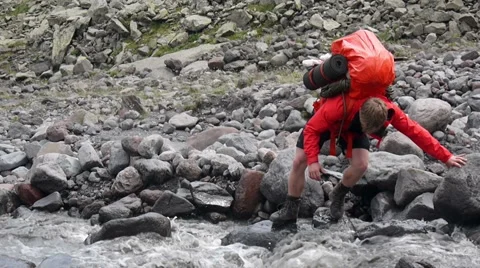 Backpacker trying to cross the river Stock Footage 43248790