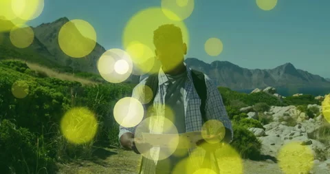 Backpacker unfolding map on coastal trail and causing animated yellow circles Stock Footage 314408241