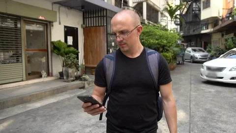 Backpacker Using Smartphone To Navigate To Hotel in Bangkok Stock Footage 102312944
