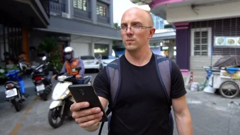 Backpacker Using Smartphone To Navigate To Hotel in Bangkok, Thailand Stock Footage 102313615
