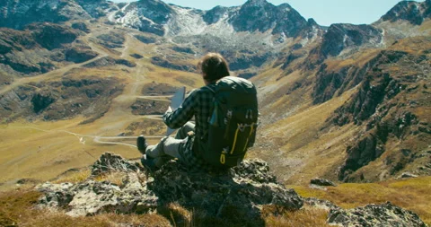 Backpacker walk and sit on rock with epic Mountain View and open laptop computer Stock Footage 247364234