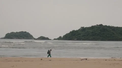 Backpacker walking alone on the beach Stock Footage 60740749