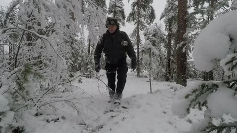 Backpacker walking back and forth through snow covered trees Stock Footage 145951938