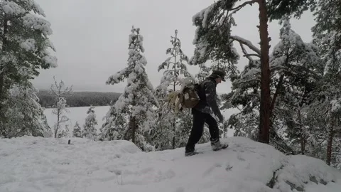 Backpacker walking back and forth at snowy hilltop Stock Footage 145952145