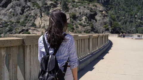 Backpacker walking on bridge in o shaughnessy dam Stock Footage 128408478