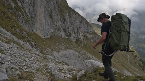 Backpacker walking down a mountain valley Stock Footage 252858009