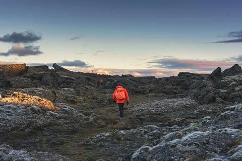 Backpacker walking on lava field in remote wilderness Stock Photos