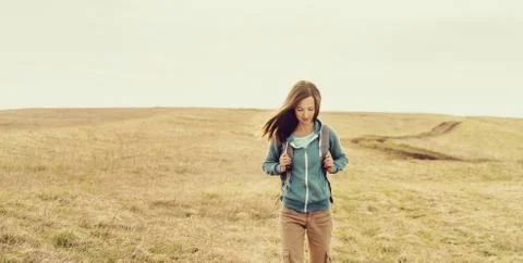 Backpacker walking on meadow Stock Photos
