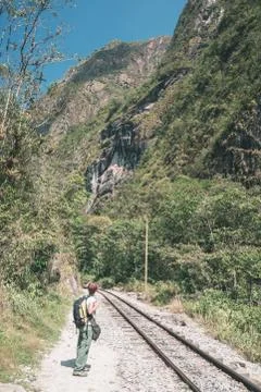 Backpacker walking on the railroad track to Machu Picchu, Peru, alternative t Stock Photos