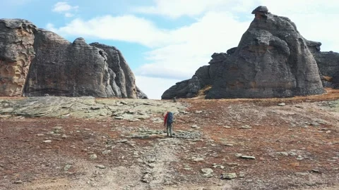 Backpacker walking on rocky path towards mountain pass Video stock 309869952