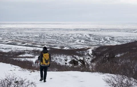 Backpacker walking on snow mountain in winter Stock Photos