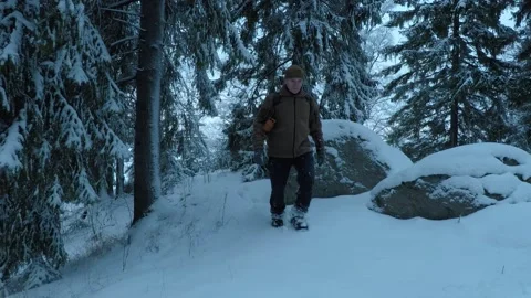Backpacker walking towards camera between big rock and trees Stock Footage 146729118