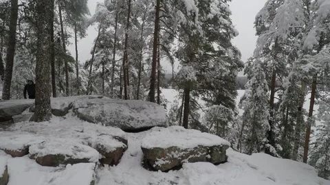Backpacker walking towards camera, over a snowy cliff Stock Footage 145952095