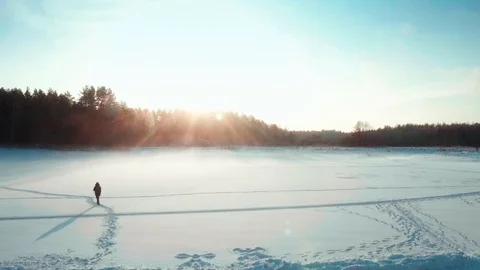 Backpacker walks through the field in winter. Making path through frozen lake Stock Footage 123074029