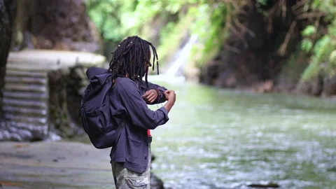 A Backpacker Young Black Man Folding His Sleeves in the Nature Stock Footage 207658520
