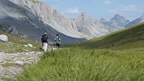 Backpackers Crossing High Alpine Valley Trail in Italian Alps Stock Footage 344590209