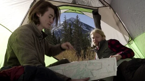 Backpackers Discuss Route, Man Points To Mountain In Distance, His Friend Looks Stock Footage 72374597
