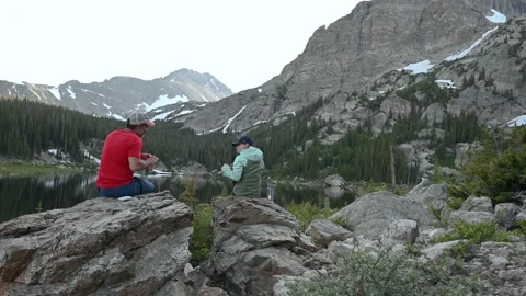 Backpackers eating at Lake Stock Footage 147933292
