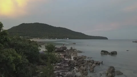 Backpackers sit on resort platform Cambodian beach flyover reaveal swimmers Stock Footage 140280580