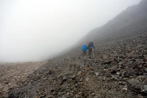 Backpackers trekking in mountains. Stock Photos