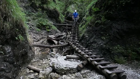 Backpacking hiker man going through rocky canyon Stock Footage 87632708