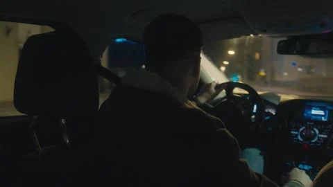 Backseat View of Driver on a Midnight Ride Through City Video stock 306322215