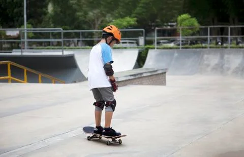 Backside of asian boy practice sketeboard on outdoor field. 写真素材