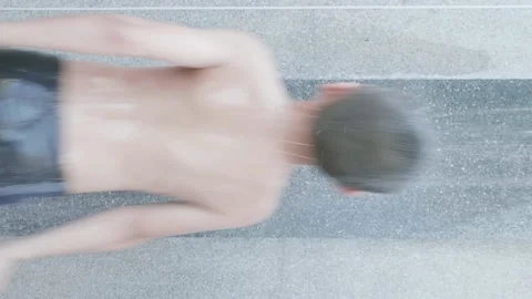 A backside of a boy is jumping taking a bath in fresh water under the shower. Stock Footage 146692564
