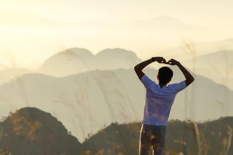 Backside of man is forming a heart shape at sunset with natural heart shaped  Stock Photos