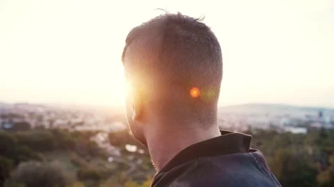 Backside or back of head of brave man observing cityscape sunrise Lens flare Stock Footage 102687142