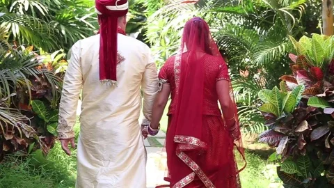 Backside View Groom and Bride Walk along Track among Plants Stock Footage 84756966
