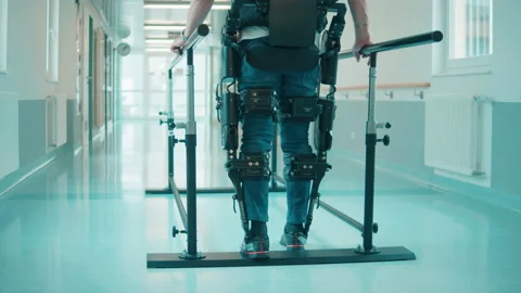 Backside view of a male patient practicing walking in exoskeleton Stock-Footage 154935652