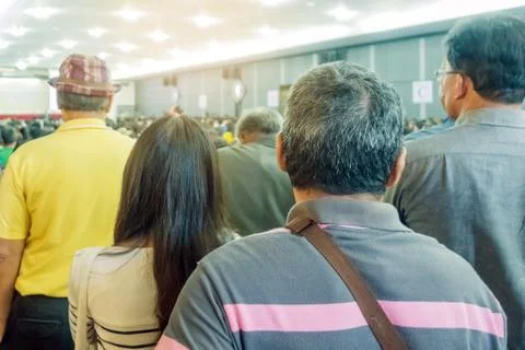 Backside view of spectators standing in a gathering in the back of auditorium Stock Photos
